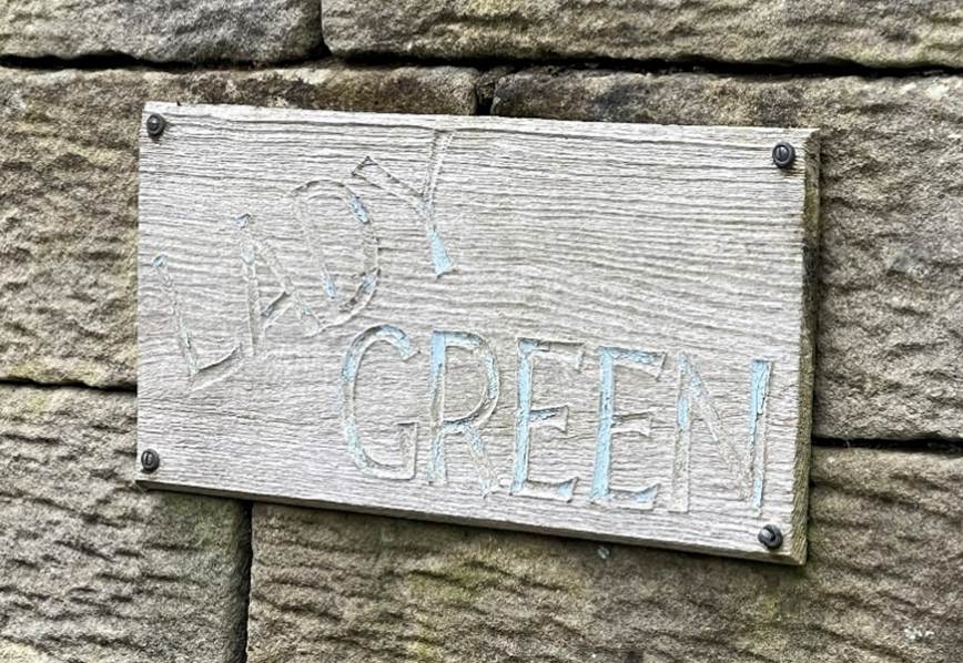 A sign on a stone wall
Description automatically generated